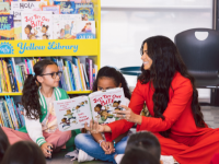  students reading a book with Camila Alves McConaughey